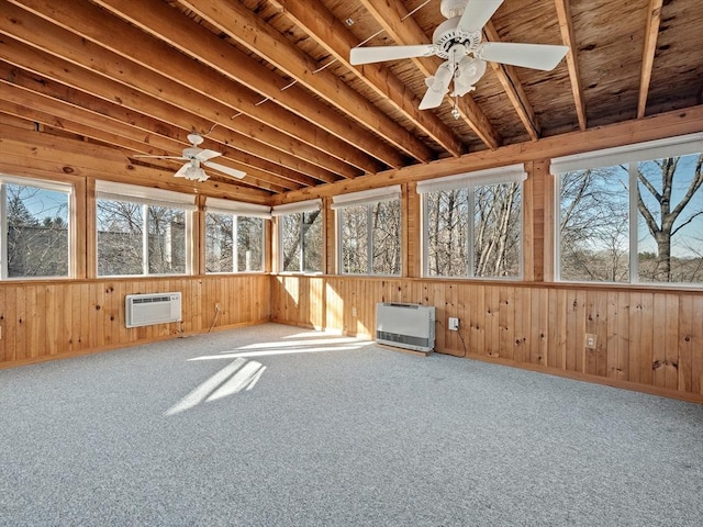 unfurnished sunroom with a wall mounted air conditioner, heating unit, a wealth of natural light, and ceiling fan