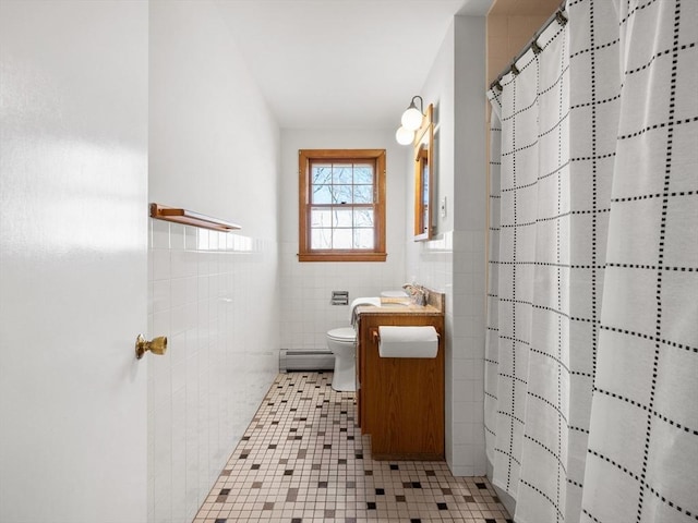 bathroom featuring a shower with shower curtain, tile patterned floors, vanity, baseboard heating, and tile walls