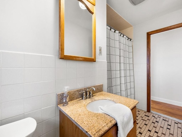 bathroom with tile patterned flooring, vanity, tile walls, and toilet