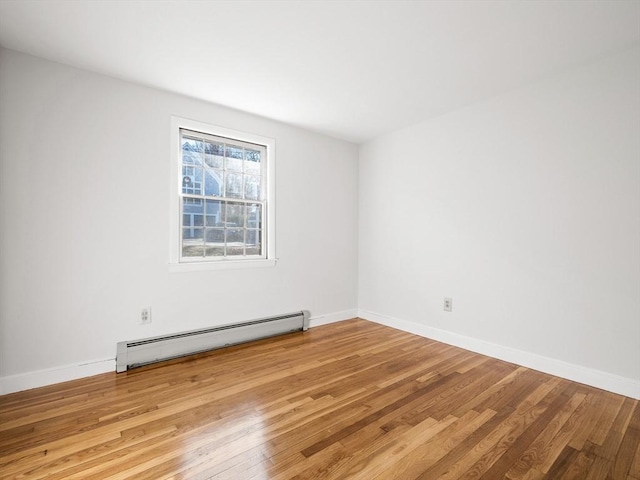 spare room with hardwood / wood-style floors and baseboard heating