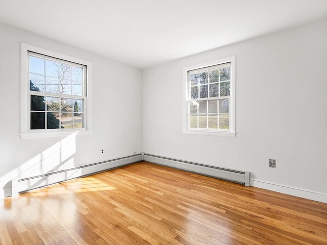 spare room with light wood-type flooring and a baseboard heating unit