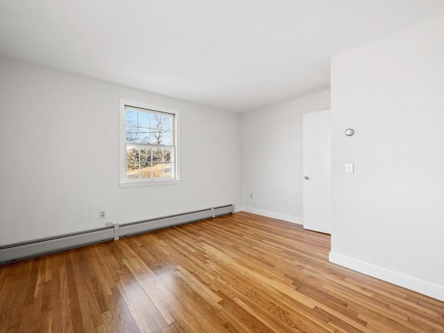 empty room featuring light hardwood / wood-style flooring and a baseboard heating unit