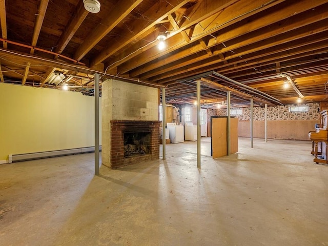 basement featuring a fireplace, separate washer and dryer, and baseboard heating