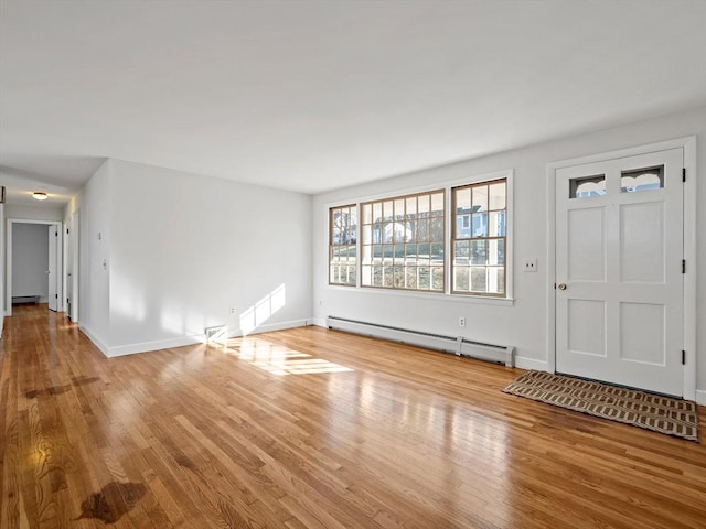 foyer with light hardwood / wood-style flooring and a baseboard heating unit