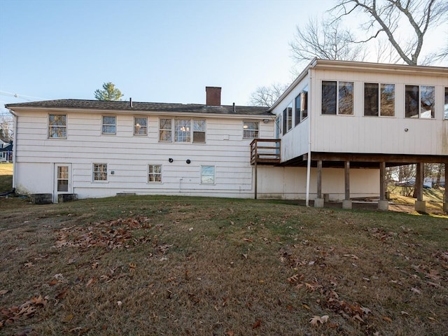 rear view of property with a sunroom and a yard