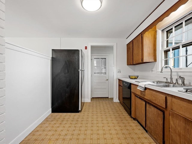 kitchen with sink, black dishwasher, and stainless steel refrigerator