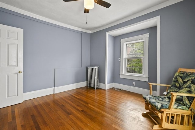 23 Highland Rd, Somerville, MA 02144 - living area featuring wood finished floors, a ceiling fan, radiator, and crown molding