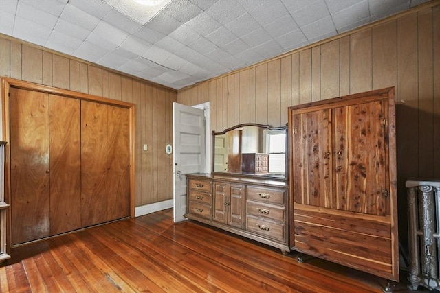 23 Highland Rd, Somerville, MA 02144 - bedroom featuring wood walls, dark wood-type flooring, and a closet