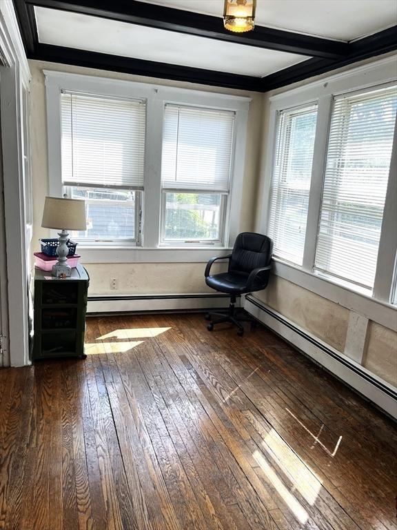 23 Highland Rd, Somerville, MA 02144 - living area with dark wood finished floors, a baseboard radiator, and beam ceiling