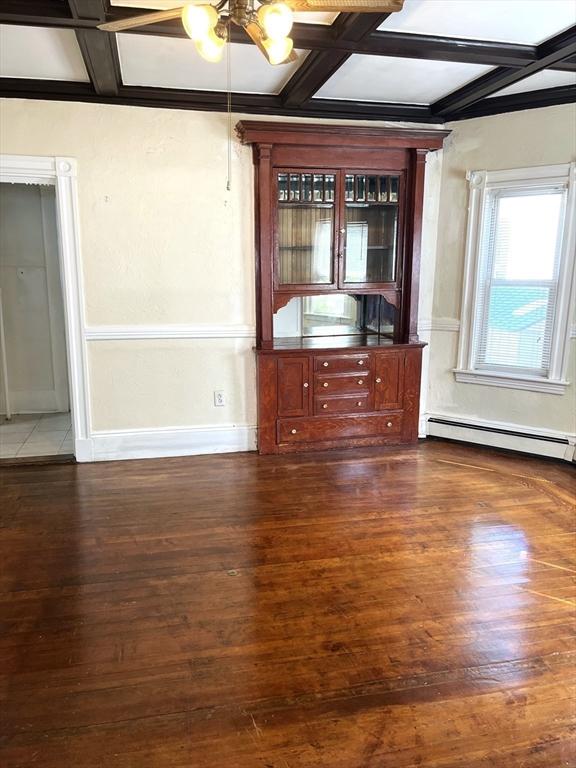 23 Highland Rd, Somerville, MA 02144 - empty room with coffered ceiling, wood finished floors, beamed ceiling, and a baseboard radiator