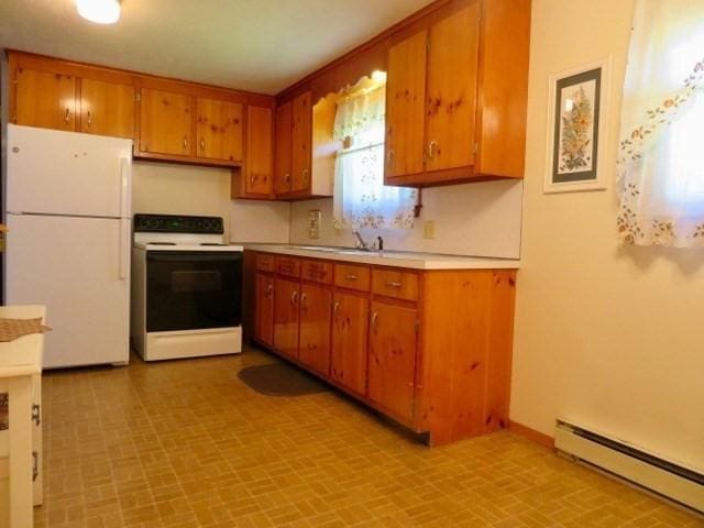 580 New Ludlow Rd, Chicopee, MA 01020 - kitchen with white appliances, a baseboard heating unit, light countertops, brown cabinets, and brick patterned floors