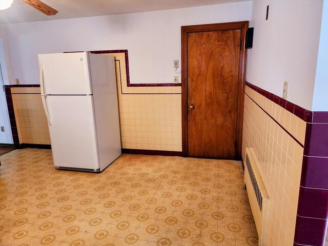 55 Kilburn St, Revere, MA 02151 - kitchen with a wainscoted wall, tile walls, freestanding refrigerator, and light floors