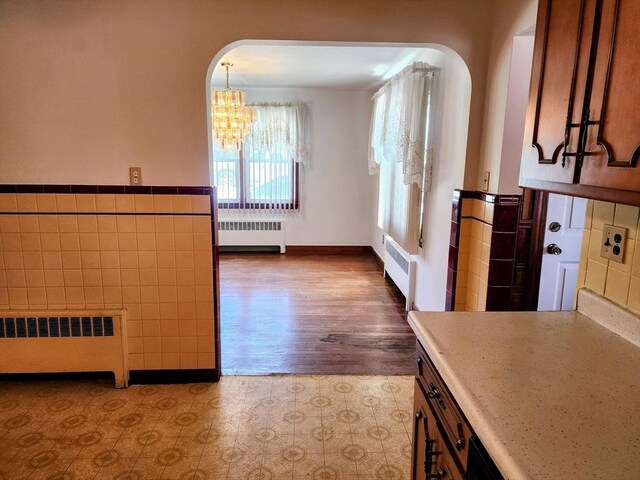 55 Kilburn St, Revere, MA 02151 - unfurnished dining area featuring radiator, tile walls, and a chandelier