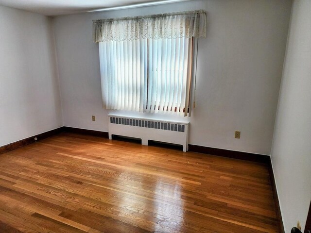 55 Kilburn St, Revere, MA 02151 - empty room featuring radiator, wood finished floors, and baseboards