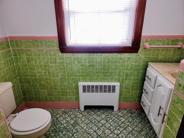 55 Kilburn St, Revere, MA 02151 - half bath featuring radiator, tile walls, vanity, toilet, and a wainscoted wall