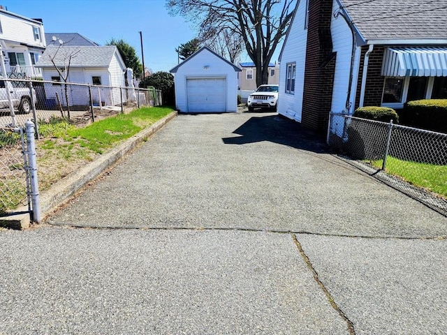 55 Kilburn St, Revere, MA 02151 - view of home's exterior featuring an outbuilding, aphalt driveway, a detached garage, a chimney, and fence
