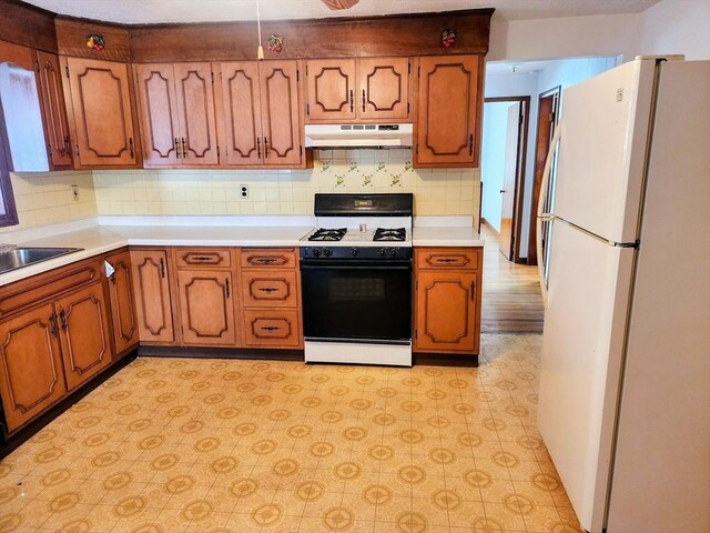 55 Kilburn St, Revere, MA 02151 - kitchen with light floors, freestanding refrigerator, gas range, under cabinet range hood, and light countertops