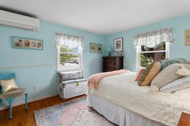 2 Olympia Ave, Woburn, MA 01801 - bedroom with a wall mounted AC, wood finished floors, and baseboards