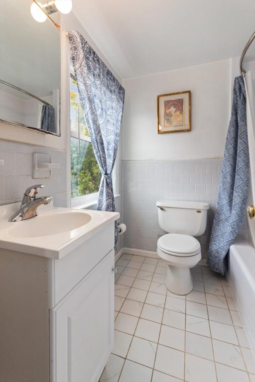 2 Olympia Ave, Woburn, MA 01801 - bathroom with tile walls, vanity, toilet, tile patterned flooring, and shower / tub combo with curtain