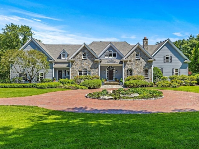 21A Farm St, Dover, MA 02030 - view of front of house with stone siding, a chimney, and a front yard