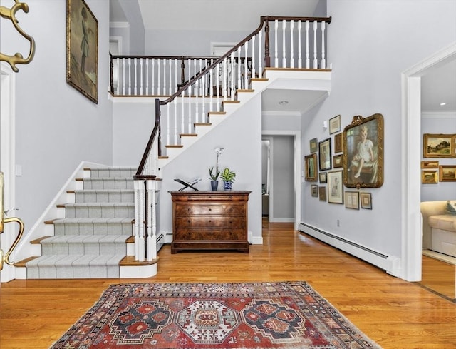 21A Farm St, Dover, MA 02030 - entrance foyer featuring a baseboard radiator, stairway, wood finished floors, crown molding, and baseboards