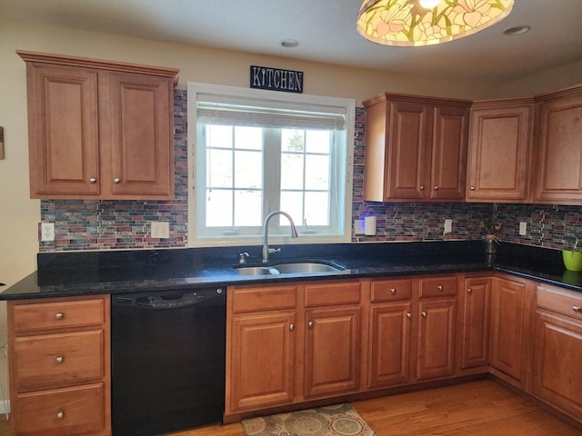 kitchen with black dishwasher, sink, decorative backsplash, dark stone counters, and light wood-type flooring