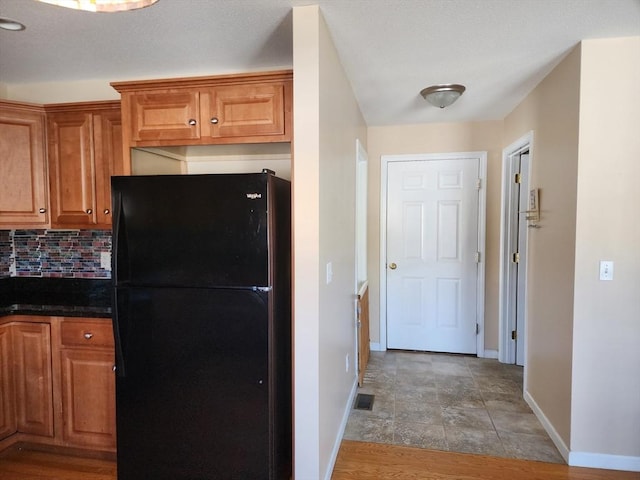 kitchen featuring tasteful backsplash and black fridge