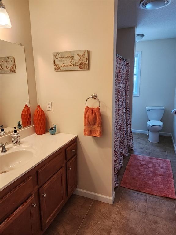 bathroom with vanity, tile patterned floors, and toilet