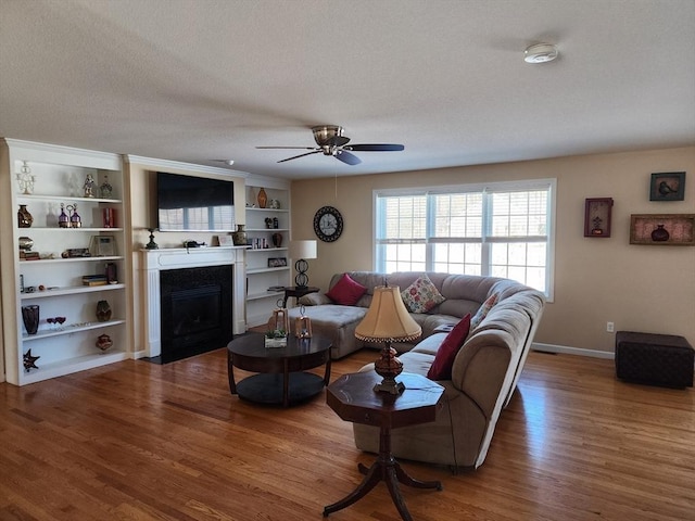 living room featuring hardwood / wood-style floors, a textured ceiling, and ceiling fan