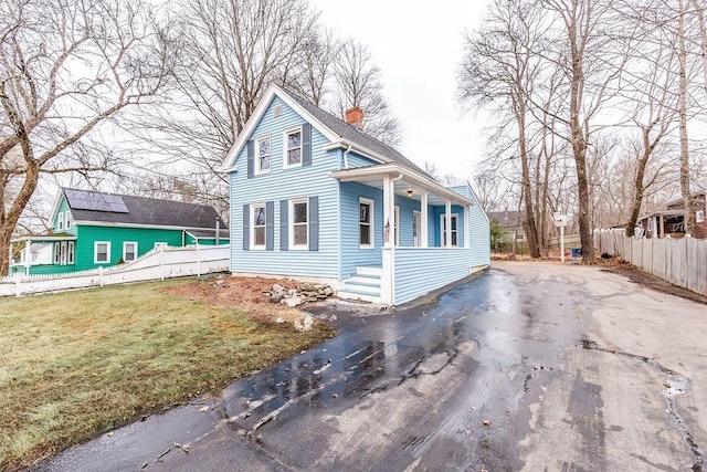 view of home's exterior featuring a porch and a yard