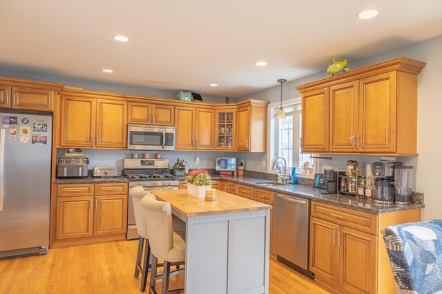 kitchen with a center island, brown cabinetry, appliances with stainless steel finishes, and a sink
