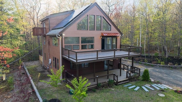 back of house with a deck and a forest view