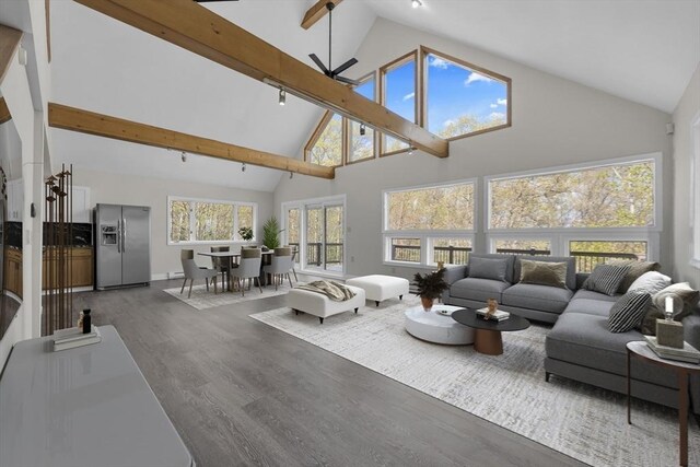 living room featuring beam ceiling, wood finished floors, high vaulted ceiling, a ceiling fan, and baseboards