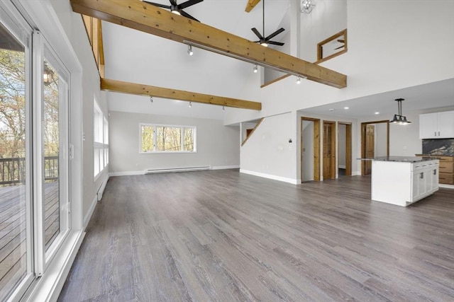 unfurnished living room featuring dark wood-style floors, ceiling fan, high vaulted ceiling, and baseboard heating