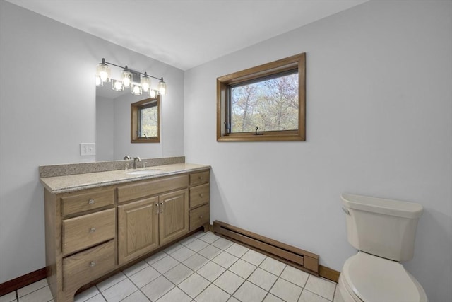 bathroom featuring toilet, baseboards, baseboard heating, and a healthy amount of sunlight