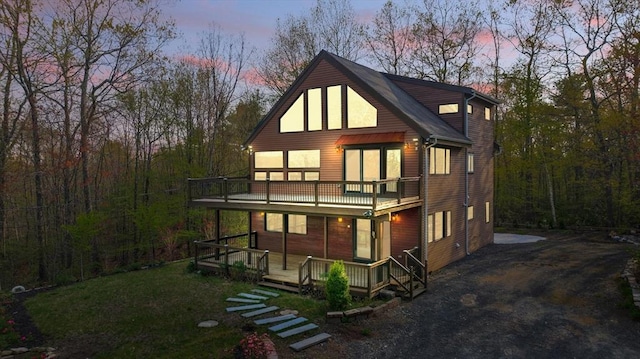 rear view of house featuring covered porch and a balcony