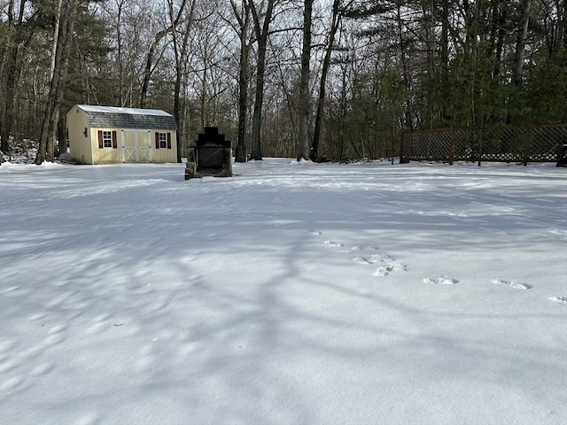 yard layered in snow with a storage unit