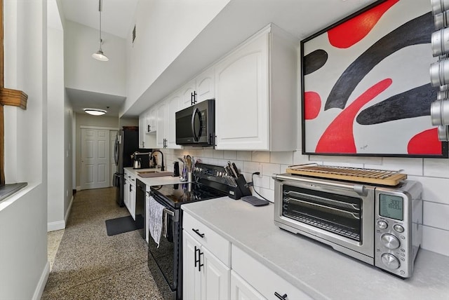 235 State St Unit 406, Springfield, MA 01103 - kitchen with black appliances, baseboards, white cabinetry, speckled floor, and tasteful backsplash
