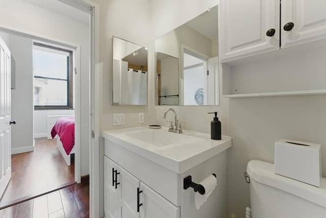 235 State St Unit 406, Springfield, MA 01103 - full bath featuring wood finished floors, toilet, vanity, and baseboards