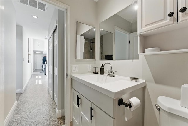 235 State St Unit 406, Springfield, MA 01103 - bathroom featuring baseboards, toilet, speckle patterned floor, and vanity