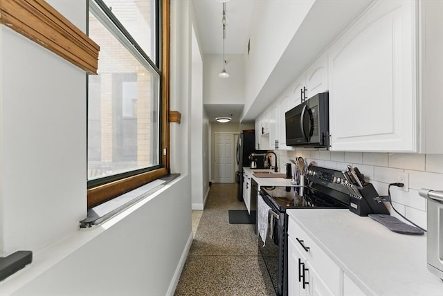 235 State St Unit 406, Springfield, MA 01103 - kitchen featuring black microwave, electric stove, speckled floor, baseboards, and white cabinets