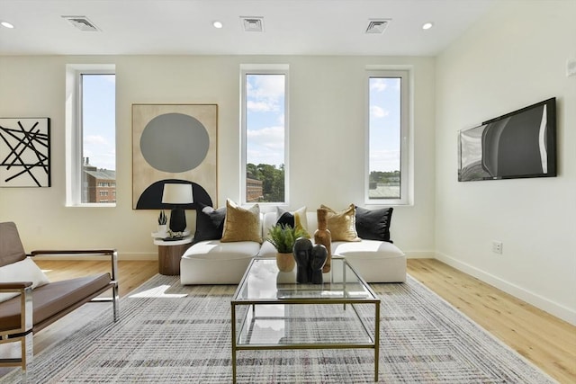 living area featuring visible vents and wood finished floors