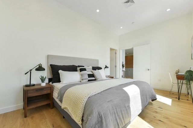 bedroom featuring baseboards, light wood-style flooring, visible vents, and recessed lighting