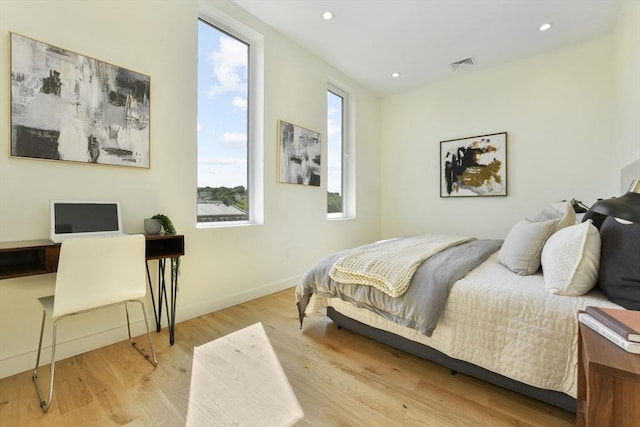 bedroom featuring baseboards, visible vents, wood finished floors, and recessed lighting