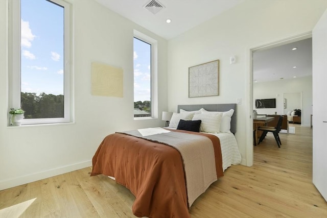 bedroom with light wood finished floors, recessed lighting, visible vents, and baseboards