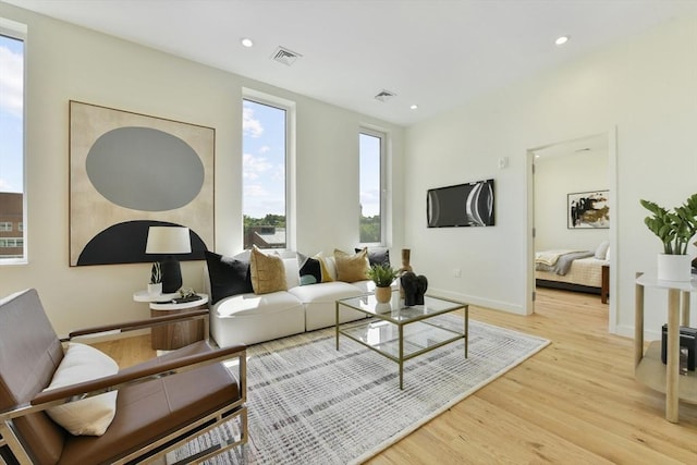 living room with recessed lighting, baseboards, visible vents, and light wood finished floors