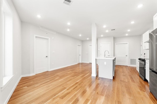 kitchen featuring light countertops, white cabinets, visible vents, and electric range oven