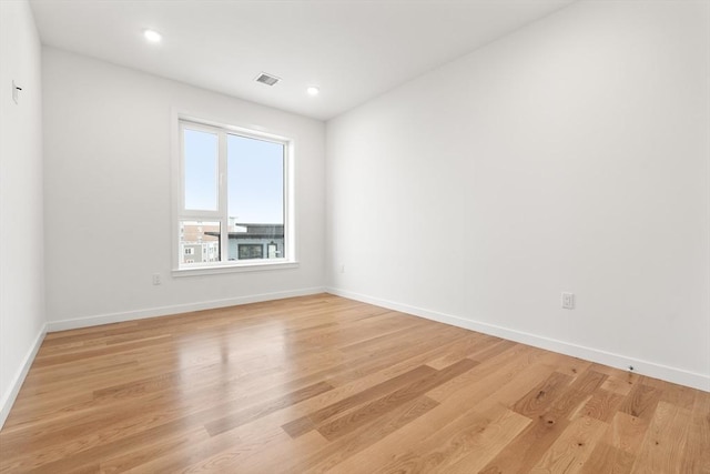 unfurnished room with recessed lighting, baseboards, visible vents, and light wood finished floors