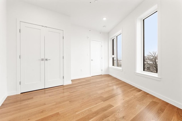 interior space featuring light wood-type flooring, baseboards, and recessed lighting