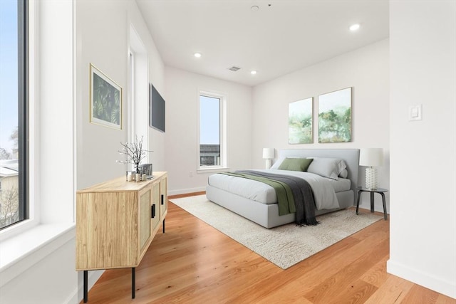 bedroom featuring light wood-type flooring, baseboards, visible vents, and recessed lighting